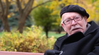 Yaşlı büyükbaba işaret parmağını kameraya doğru sallıyor. Dede tartışıyor.