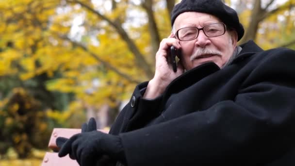 El anciano se comunica con sus parientes en un teléfono móvil — Vídeos de Stock