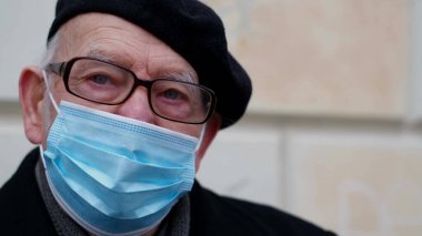 Koronavirüse karşı koruyucu maskeli yaşlı bir emekli..