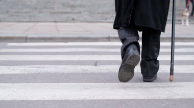 Bir adam sopayla caddeyi geçiyor..