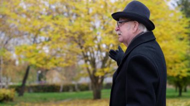 Yaşlı büyükbaba yan tarafı gösteriyor..