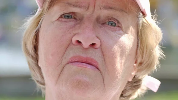 Das Gesicht einer aufgebrachten Großmutter, sie blickt nachdenklich in die Kamera. — Stockfoto