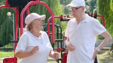 Egzersiz makinelerinde parktaki olgun çift..