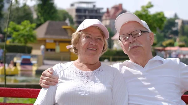 Un cuplu în vârstă se odihnește pe o bancă într-un parc de vară. — Fotografie, imagine de stoc