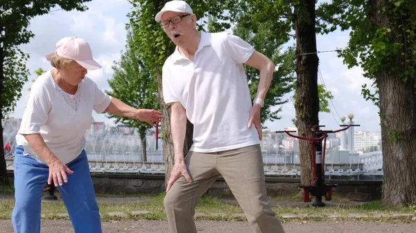 Sabah egzersizi sırasında bel ağrısı çeken yaşlı bir büyükbaba. Yaşlı emeklilerin sağlık sorunları.