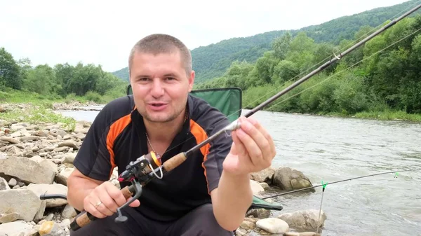 Een mannelijke visser blogs en vertelt de camera over visaas. — Stockfoto