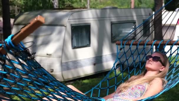 La chica está descansando en una hamaca. Campamento de día en el bosque. — Vídeos de Stock