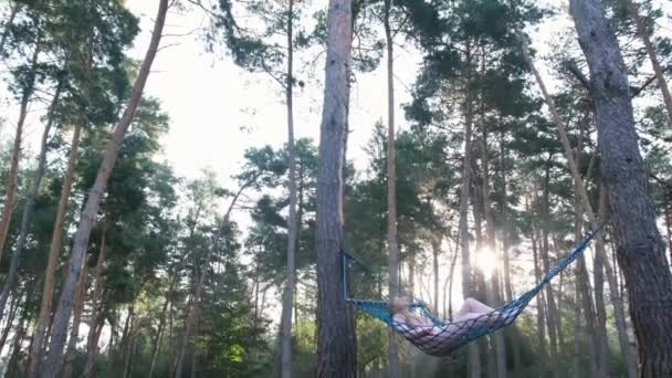 Mulher descansando na rede ao ar livre. Relaxe e desfrute da natureza na floresta . — Vídeo de Stock