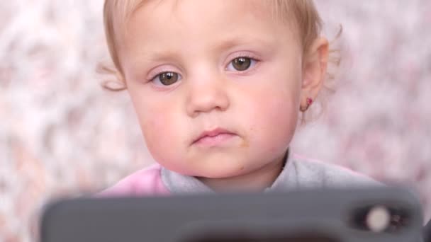 Little girl watching cartoon from the phone. — Video Stock