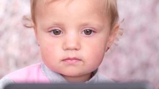 Cute baby close up. She is watching cartoons on smartphone. — Video Stock