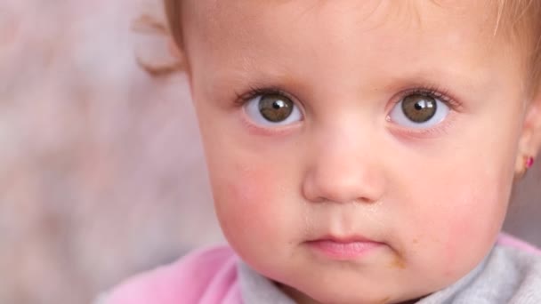 Närbild porträtt av en söt ledsen bebis med stora ögon. — Stockvideo
