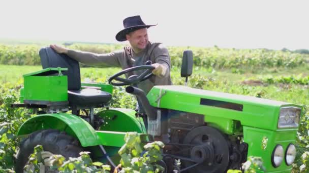 Gelukkige boer zit achter een nieuwe tweewielige trekker. — Stockvideo