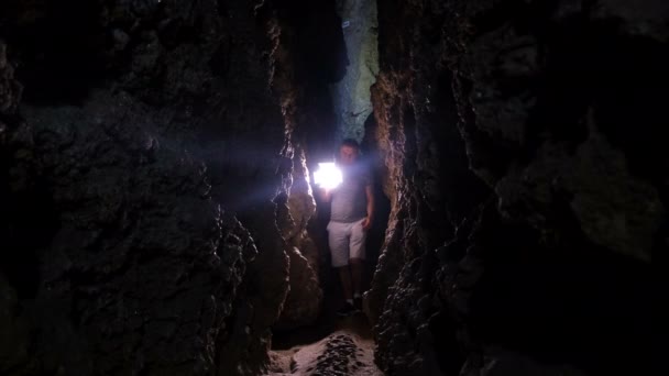 Un jeune homme explore une immense grotte avec des torches. — Video