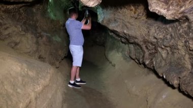 Adam turist zindandaki mağaraların fotoğraflarını çekiyor..