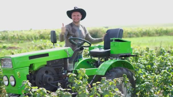 Atraktivní mladý farmář stojící u traktoru. — Stock video