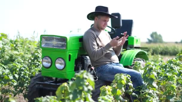 Rural guy farmer uses a smartphone. The concept of agriculture. — Stockvideo