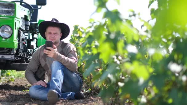 Αγροτικός αγρότης χρησιμοποιεί ένα smartphone. Η έννοια της γεωργίας. — Αρχείο Βίντεο