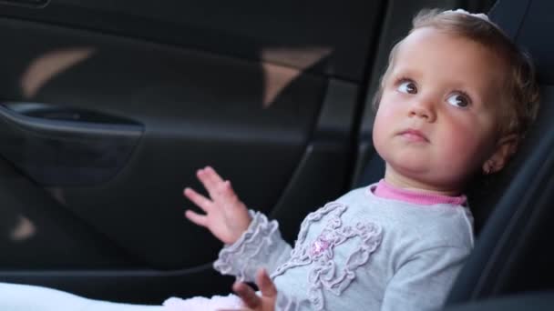 Little baby sitting in the car. Child in the front seat of the car — Stock videók