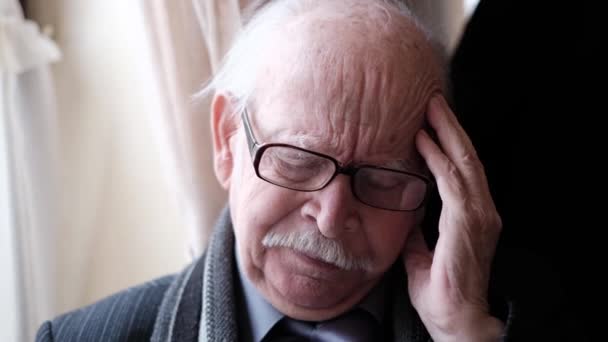 Hoofdpijn in een oude grijsharige grootvader, zijn leeftijd is 85 jaar. — Stockvideo