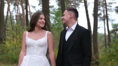 Parkta duygularını ifade eden genç ve seksi bir çift. Gelin ve damat dışarıda öpüşüyor..