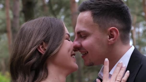 Young sexy couple expressing feelings in the park. The bride and groom kissing outdoors. — Stock Video