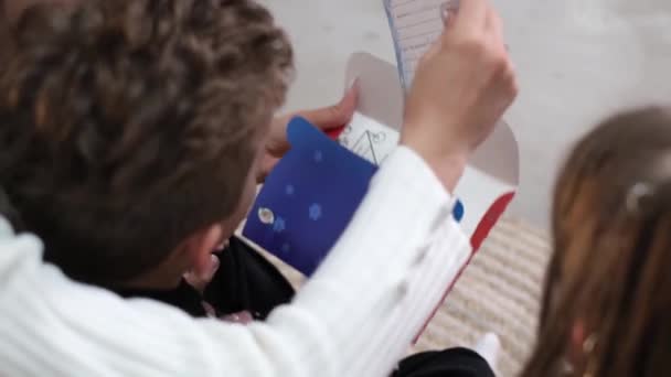 ママと子供たちはサンタクロースに手紙を書く幸せな家族 — ストック動画