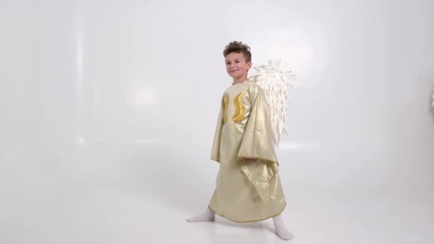 Маленький мальчик с ангельскими крыльями на белом фоне. — стоковое видео