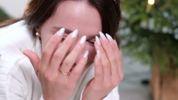 Közelkép egy fiatal nőről, aki mindkét kezével eltakarja az arcát.. — Stock videók