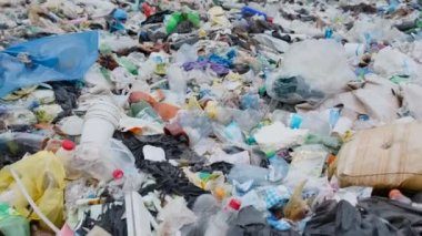 Çöplükte bir sürü plastik torba var. İnsansız hava aracı plastik çöp şişelerinin üzerinde çok alçaktan uçuyor.. 