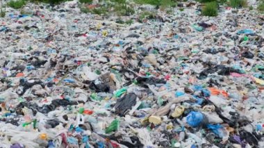 Çöplükte bir sürü plastik torba var. İnsansız hava aracı plastik çöp şişelerinin üzerinde çok alçaktan uçuyor.. 