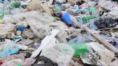 Büyük bir çöp yığını, bir sürü plastik torba, doğal çevrede çöp..