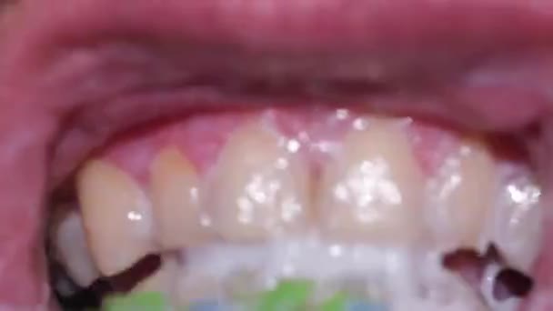 Close-up of a young man while brushing his teeth, personal hygiene. — Stock Video