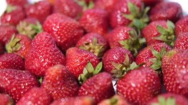 Kürsüde dönen güzel kırmızı çileklerin video arkaplanı. 