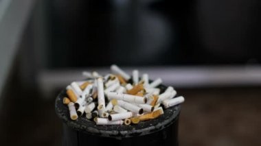 The man throws the cigarette butt into the ashtray. Bad habits, smoking