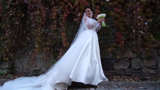 Прекрасная невеста, стоящая возле деревьев в осеннем лесу. — стоковое видео