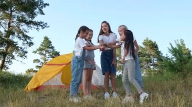 Çocuklar yazın ormanda dinleniyorlar. Küçük kızlar ve oğlanlar kamp için çadır kurdular.. 