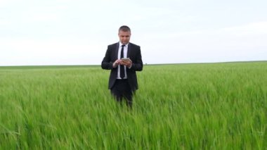 Bir tarım işçisi yeşil bir alanda tablet üzerinde çalışıyor.. 