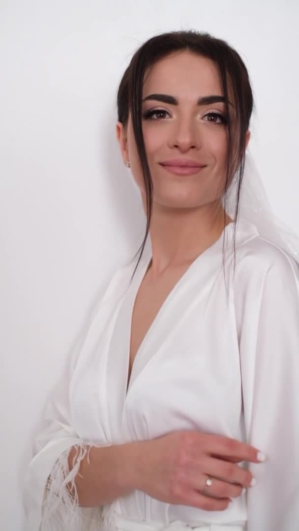 Элегантная брюнетка невеста в белом халате по утрам, красивая девушка с большими глазами — стоковое видео