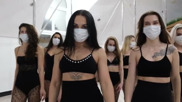 Grupo de chicas hermosas en un desfile de moda, que están en una máscara protectora contra el coronavirus. — Vídeos de Stock