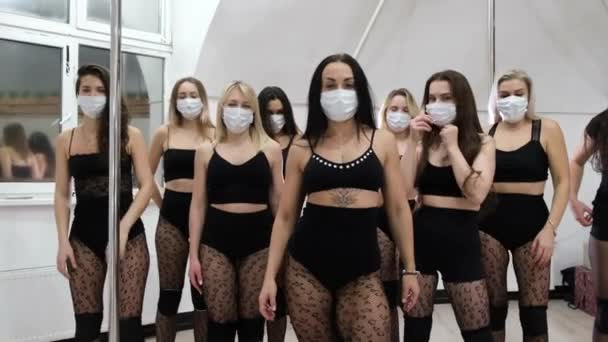 Chica glamurosa en ropa sexy negro y máscaras protectoras. Grupo de mujeres que van a la pista de baile. — Vídeos de Stock