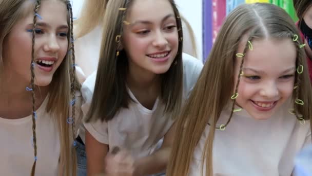 A group of teenage girls look at the monitor and laugh emotionally. Use of social networks — Stock Video