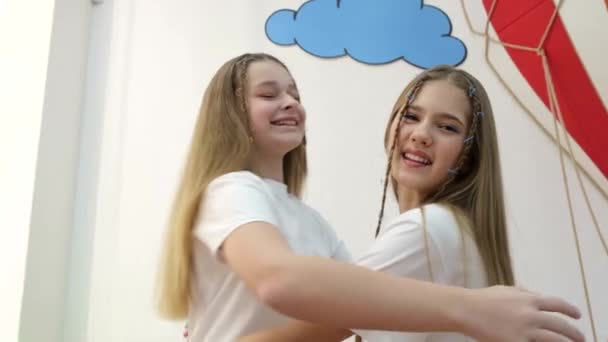 Two little sister girls sincerely hug, they are wearing white T-shirts. — Stock Video