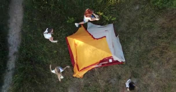 Barnen springer runt i det gula tältet, de vilar utomhus i skogen. — Stockvideo