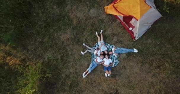 Střelba z dronu. Děti odpočívají u žlutého stanu v lese.. — Stock video