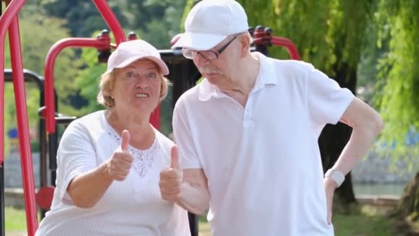 Familia de jubilados en un calentamiento matutino en un parque de la ciudad, alegremente muestran pulgares hacia arriba. — Vídeo de stock