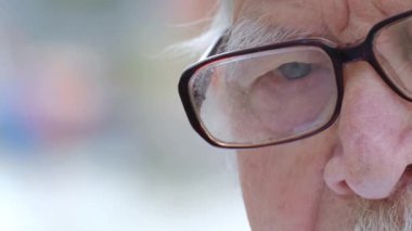 Yaşlı bunalımlı bir dedeye yakından bakın. Gri saçlı ve gözlük takıyor..