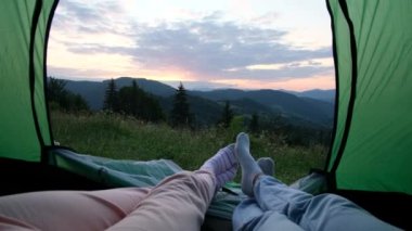 Sevgi dolu bir çift dağlarda dinleniyor, çadırda oturup konuşuyorlar. Bütçe turistleri