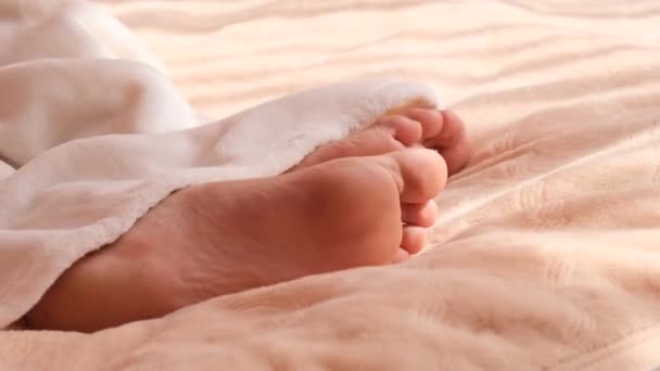 男のベッドで寝て、足の上からの眺め。ベッド毛布。4k — ストック動画