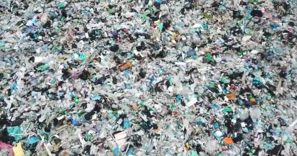 Купи сміття, пластикових і скляних пляшок, розкиданих по землі в пластикових пакетах . — стокове відео