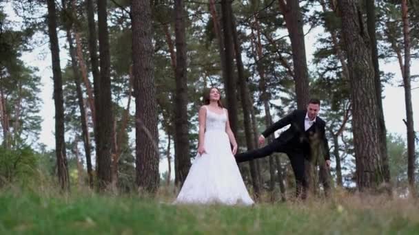 Šťastná dvojice nevěst procházejících se v městském parku, svatební den. Nevěsta a ženich objímají a líbají — Stock video